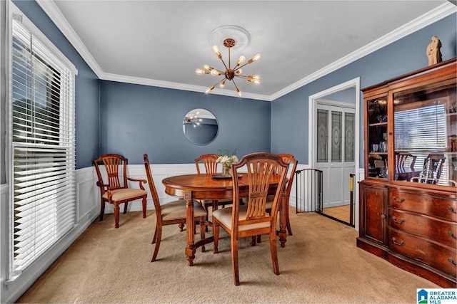 dining space with an inviting chandelier, ornamental molding, and light carpet