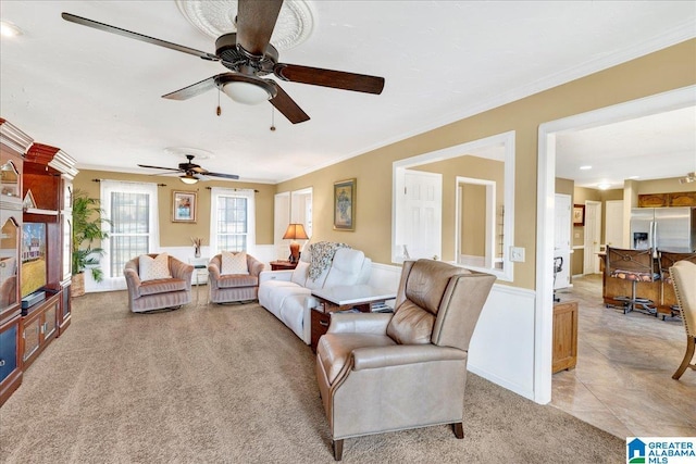 carpeted living room featuring ceiling fan and ornamental molding