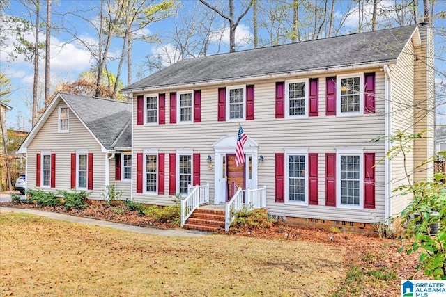 colonial-style house featuring a front lawn