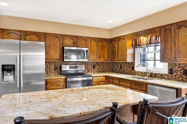 kitchen featuring sink, stainless steel appliances, a kitchen bar, and tasteful backsplash