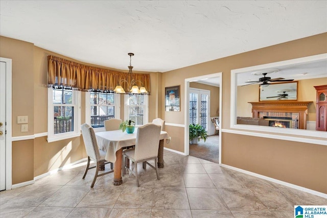 tiled dining area featuring ceiling fan with notable chandelier and a healthy amount of sunlight