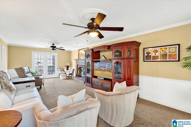 living room featuring ornamental molding, ceiling fan, and carpet