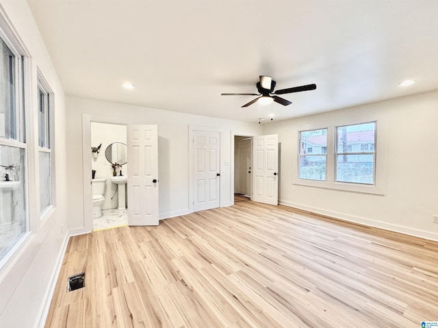 unfurnished bedroom featuring ensuite bathroom, ceiling fan, and light hardwood / wood-style floors