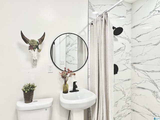 bathroom featuring curtained shower, toilet, and sink