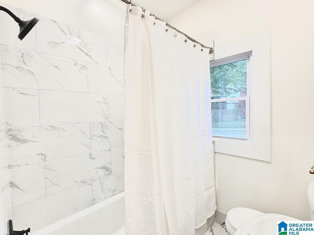 bathroom with toilet and shower / tub combo