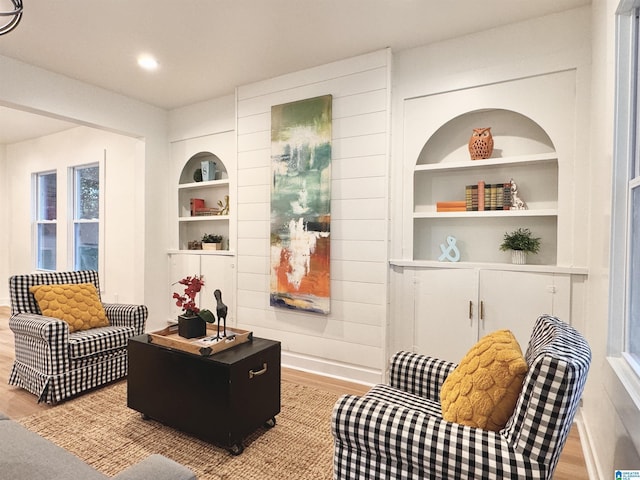 living area with light hardwood / wood-style floors and built in shelves