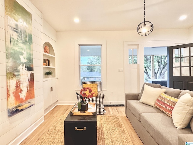 living room with light wood-type flooring and built in features