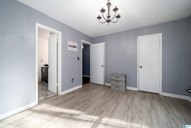 unfurnished bedroom featuring light hardwood / wood-style flooring and an inviting chandelier