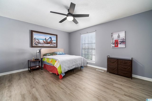 bedroom featuring a textured ceiling, light hardwood / wood-style flooring, and ceiling fan