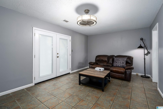 living room with a textured ceiling and french doors