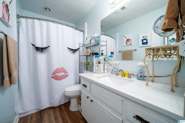 bathroom with wood-type flooring, toilet, and vanity