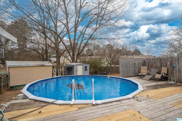 view of swimming pool with a wooden deck and a storage unit