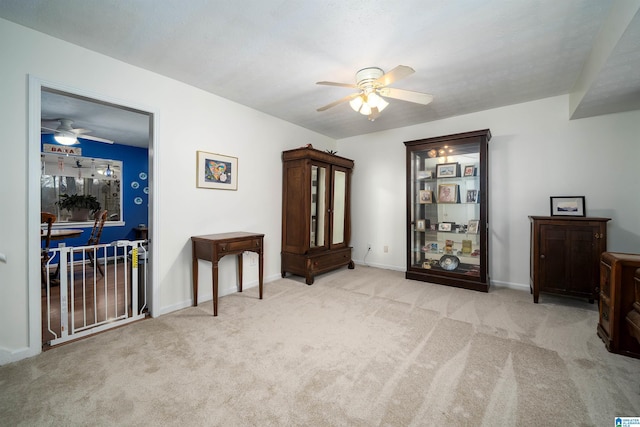 interior space with light carpet and ceiling fan