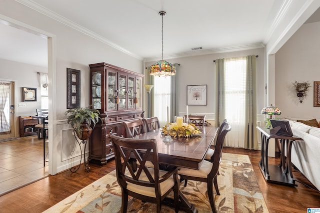 dining area with ornamental molding and dark wood-type flooring