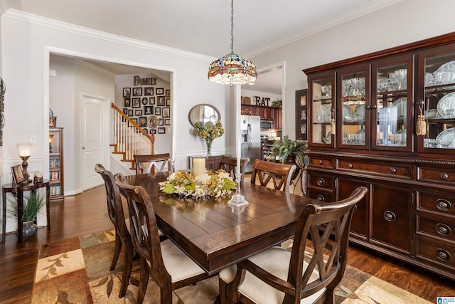 dining area with dark wood-type flooring and crown molding