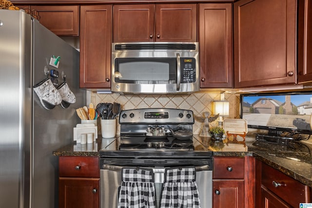 kitchen featuring dark stone counters, appliances with stainless steel finishes, and tasteful backsplash