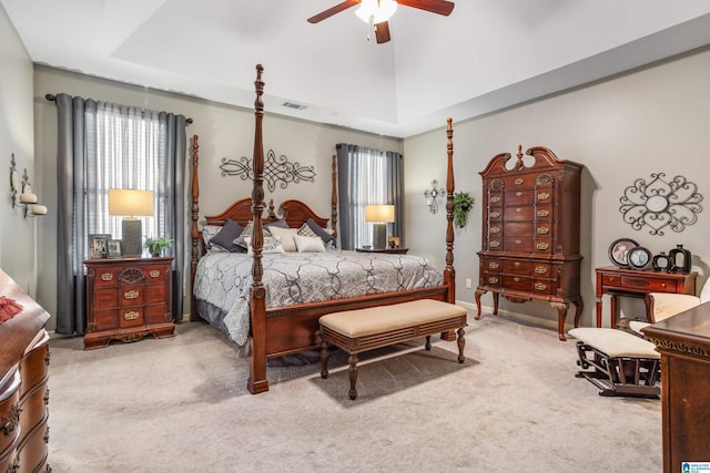 bedroom featuring a raised ceiling, ceiling fan, and carpet