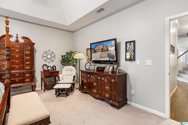 living area featuring lofted ceiling, ornamental molding, and light colored carpet