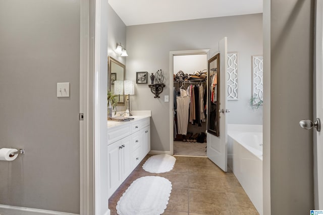 bathroom with tile patterned flooring, vanity, and a bathing tub