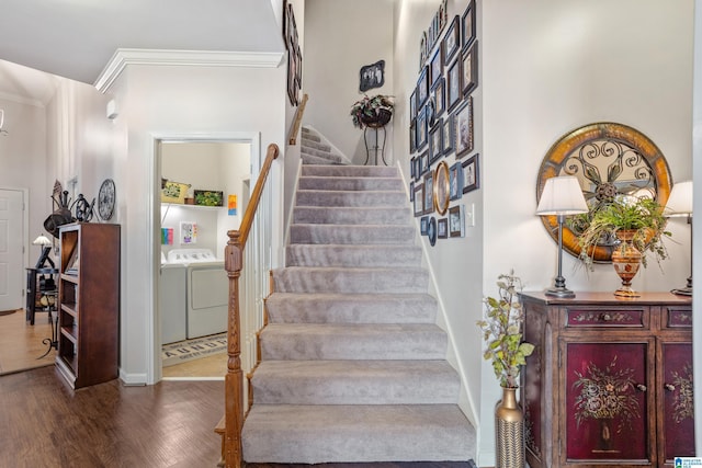 staircase with wood-type flooring, ornamental molding, and independent washer and dryer