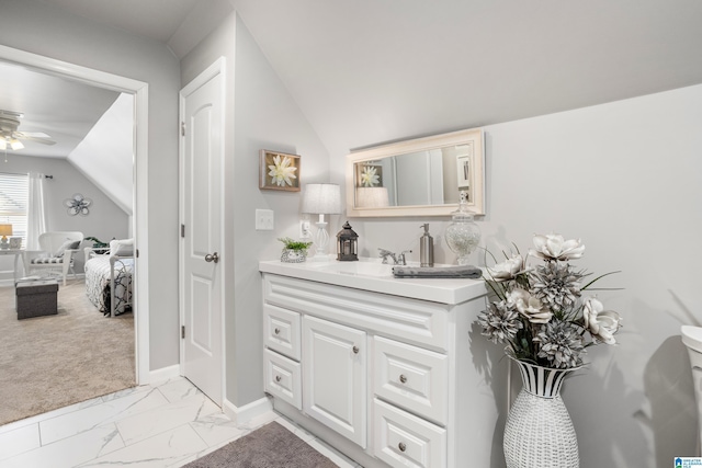 bathroom with vanity, ceiling fan, and vaulted ceiling