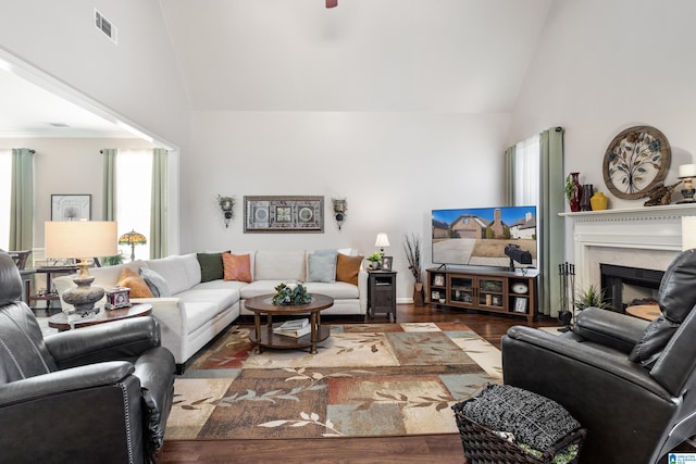 living room featuring dark wood-type flooring, ceiling fan, and vaulted ceiling