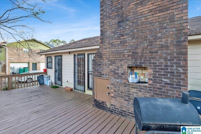 wooden terrace featuring a grill