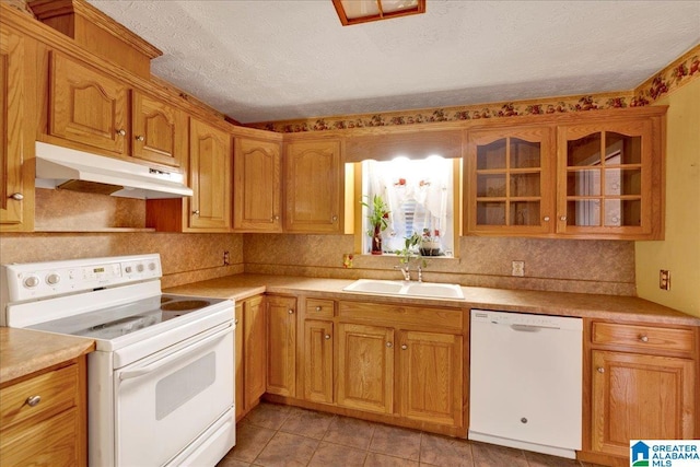 kitchen with light tile patterned floors, sink, white appliances, and a textured ceiling