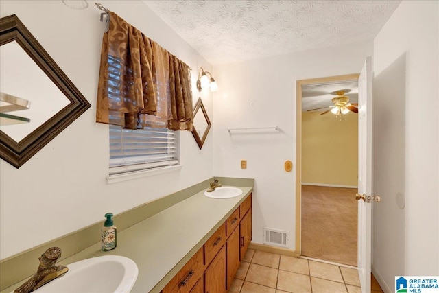 bathroom featuring ceiling fan, vanity, tile patterned floors, and a textured ceiling