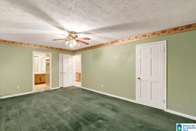 unfurnished bedroom featuring a textured ceiling, ceiling fan, dark colored carpet, and ensuite bath