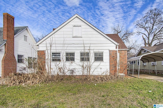 rear view of house featuring a yard and a carport