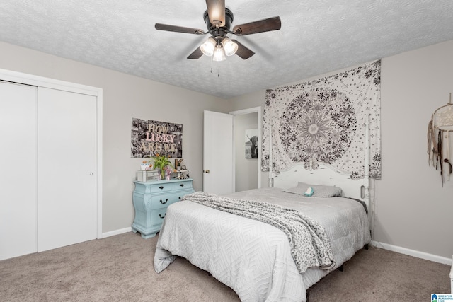 bedroom with ceiling fan, a closet, carpet floors, and a textured ceiling