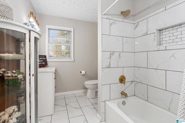 full bathroom featuring toilet, vanity, a textured ceiling, and tiled shower / bath