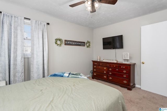 bedroom with light carpet, ceiling fan, and a textured ceiling