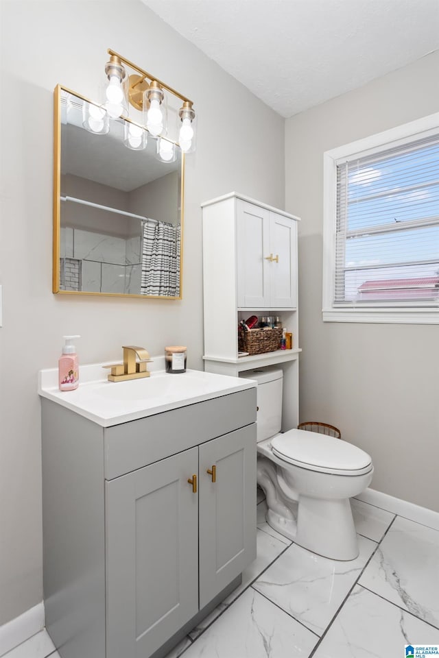 bathroom featuring toilet, walk in shower, and vanity