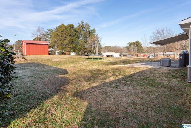 view of yard with a patio area, a storage unit, and a trampoline