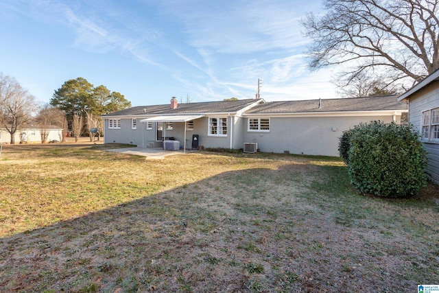 rear view of property featuring central air condition unit, a patio area, and a lawn