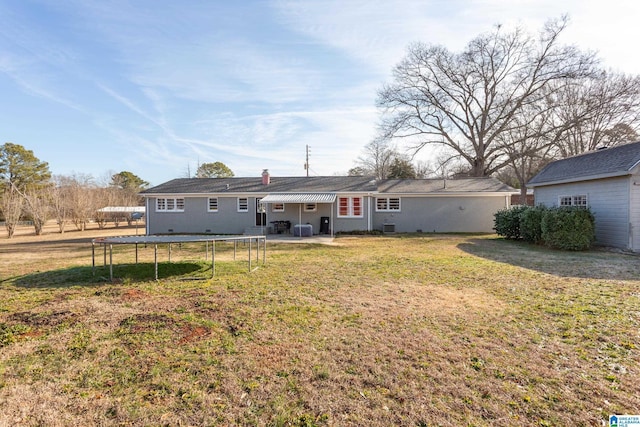 rear view of house with a lawn and central AC