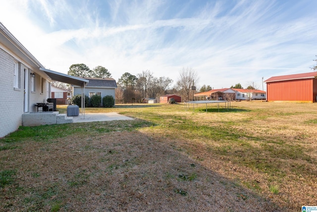 view of yard featuring a patio, a shed, and a trampoline