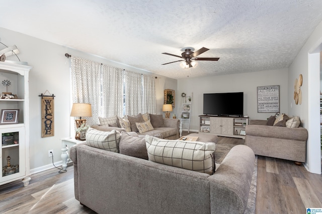 living room featuring wood-type flooring, a textured ceiling, and ceiling fan