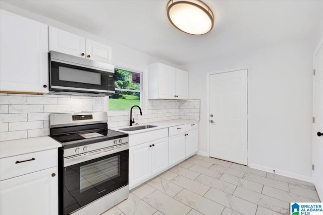 kitchen featuring stainless steel appliances, white cabinets, decorative backsplash, and sink