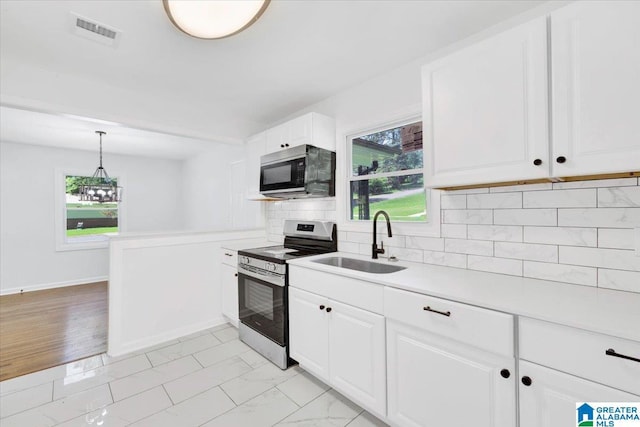 kitchen with white cabinetry, hanging light fixtures, sink, stainless steel range with electric cooktop, and tasteful backsplash