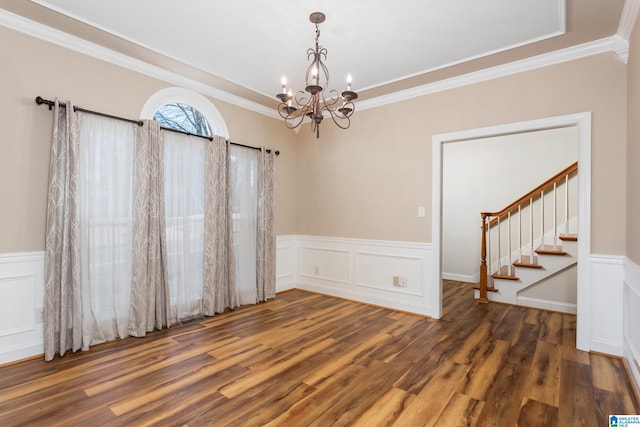 unfurnished room featuring a chandelier, dark hardwood / wood-style floors, and ornamental molding