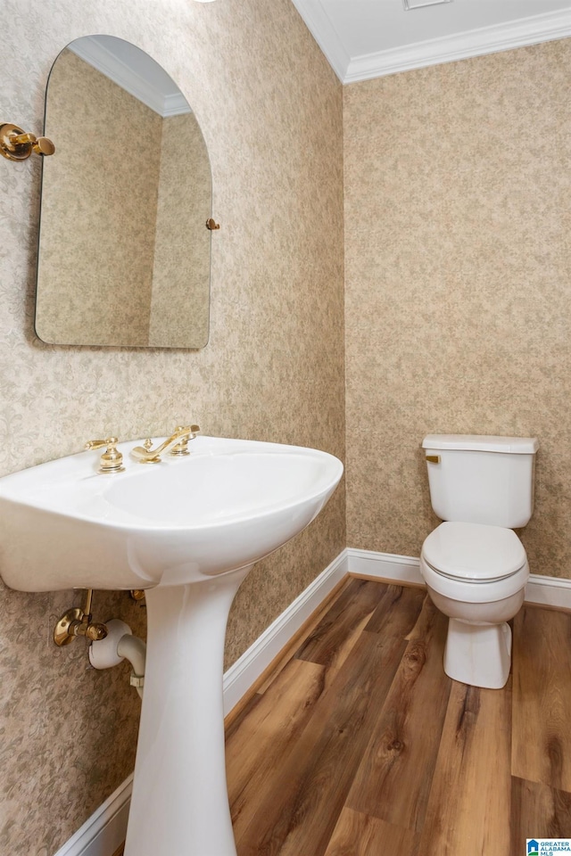 bathroom featuring hardwood / wood-style flooring, toilet, and crown molding