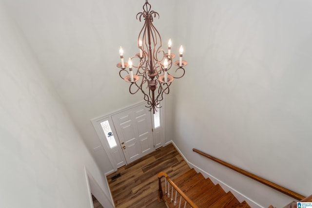 foyer with dark wood-type flooring and a notable chandelier