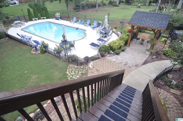 view of pool with a lawn, a gazebo, an outdoor bar, and a patio