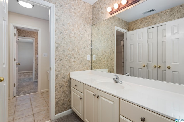 bathroom with toilet, tile patterned floors, and vanity