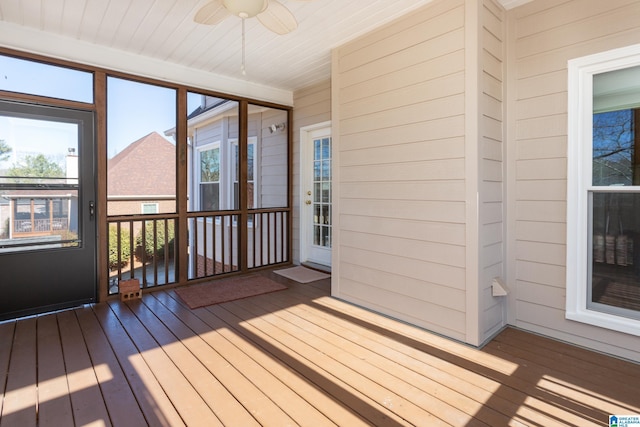 unfurnished sunroom featuring ceiling fan