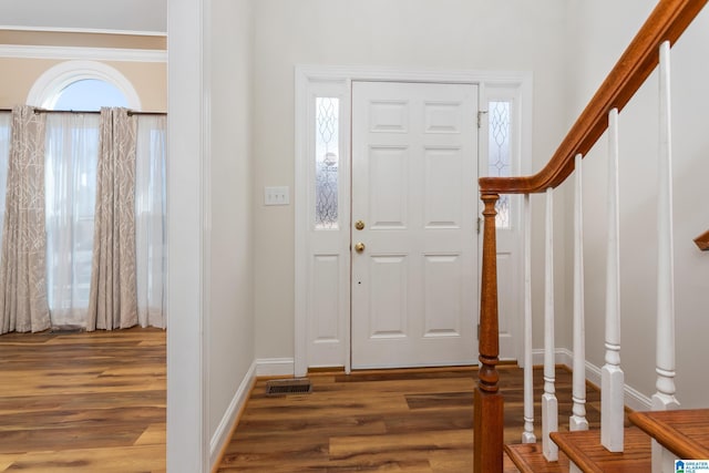 entrance foyer featuring dark hardwood / wood-style flooring and ornamental molding