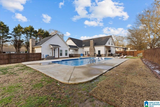 view of swimming pool with a diving board and a patio